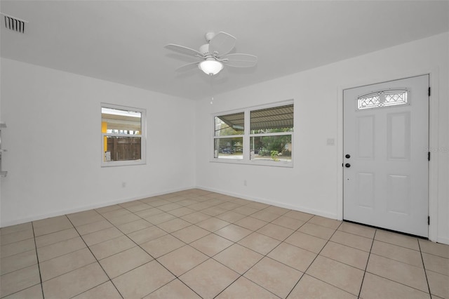 foyer entrance featuring light tile patterned floors, visible vents, a ceiling fan, and a wealth of natural light