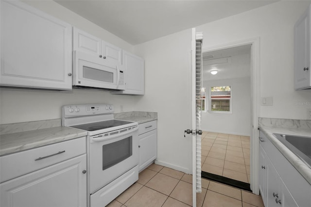 kitchen with white cabinetry, light countertops, a sink, white appliances, and light tile patterned flooring