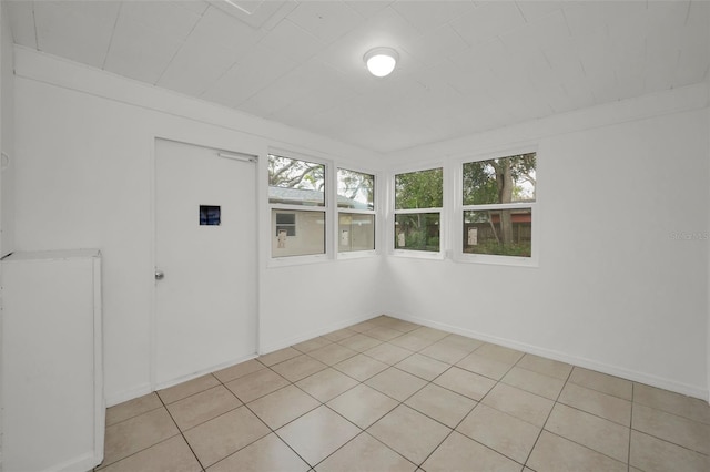 unfurnished room with baseboards and light tile patterned flooring