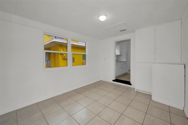 empty room featuring visible vents, baseboards, and light tile patterned floors