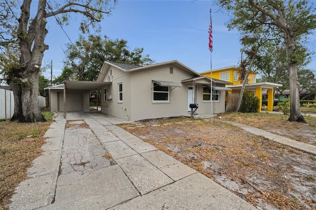 view of front of home featuring an attached carport, stucco siding, and concrete driveway