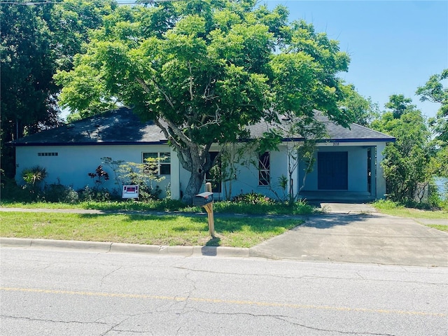 208 Shepard Ave, Dundee, FL 33838 - view of property hidden behind natural elements featuring stucco siding and a front lawn