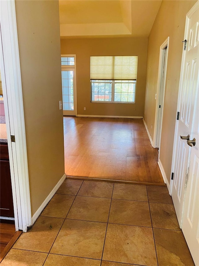 208 Shepard Ave, Dundee, FL 33838 - corridor featuring a raised ceiling, tile patterned flooring, and baseboards
