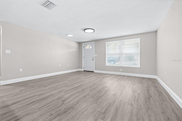 13926 Helen Ave, Hudson, FL 34667 - interior space featuring baseboards, a textured ceiling, visible vents, and wood finished floors
