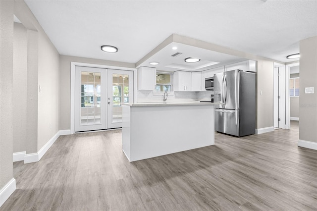 13926 Helen Ave, Hudson, FL 34667 - kitchen featuring light countertops, a raised ceiling, baseboards, stainless steel appliances, and light wood-style flooring