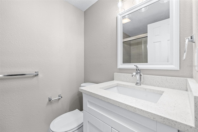13926 Helen Ave, Hudson, FL 34667 - full bath featuring vanity, toilet, a textured wall, and a stall shower