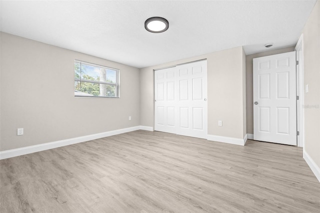 13926 Helen Ave, Hudson, FL 34667 - unfurnished bedroom with baseboards, light wood-style flooring, and a closet