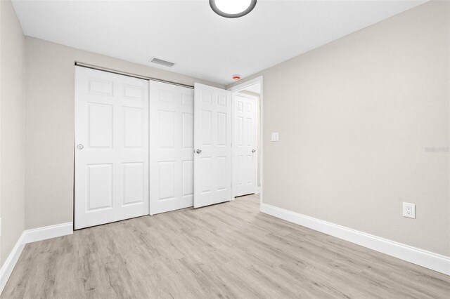 13926 Helen Ave, Hudson, FL 34667 - unfurnished bedroom featuring light wood-style floors, baseboards, a closet, and visible vents