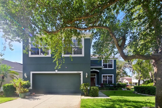 traditional-style home featuring stucco siding, an attached garage, driveway, and a front lawn