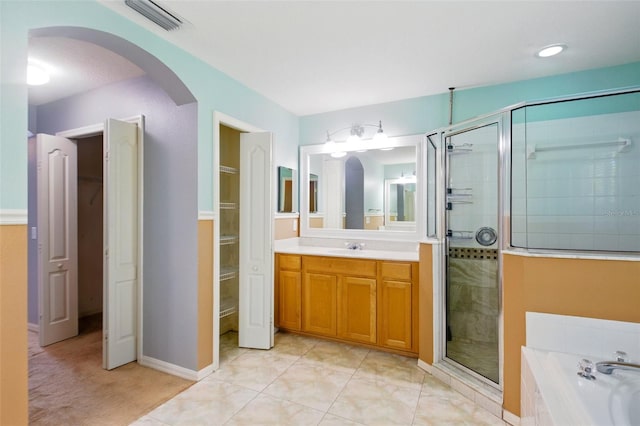 bathroom featuring visible vents, a bath, vanity, and a shower stall