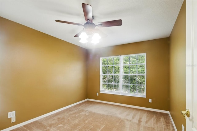 empty room with baseboards, a ceiling fan, and light colored carpet