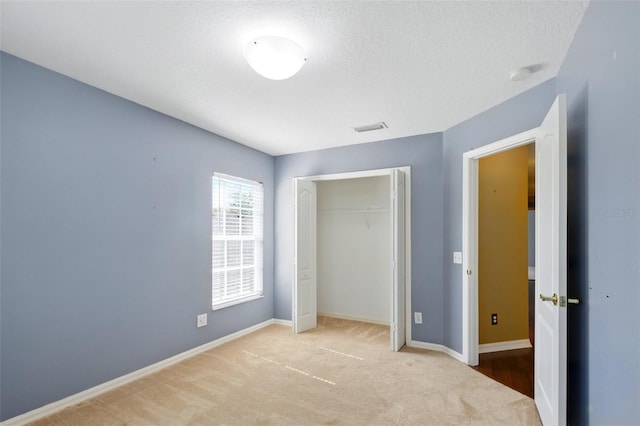 unfurnished bedroom featuring carpet floors, baseboards, visible vents, and a closet