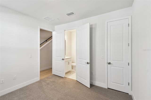 2123 1st Ave N, Saint Petersburg, FL 33713 - unfurnished bedroom with light colored carpet, baseboards, and ensuite bath