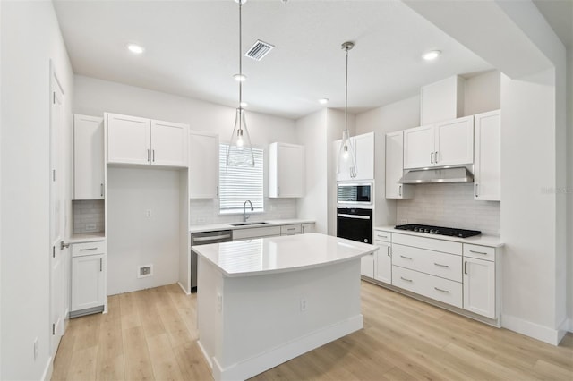 2123 1st Ave N, Saint Petersburg, FL 33713 - kitchen with black appliances, a sink, under cabinet range hood, decorative backsplash, and white cabinetry