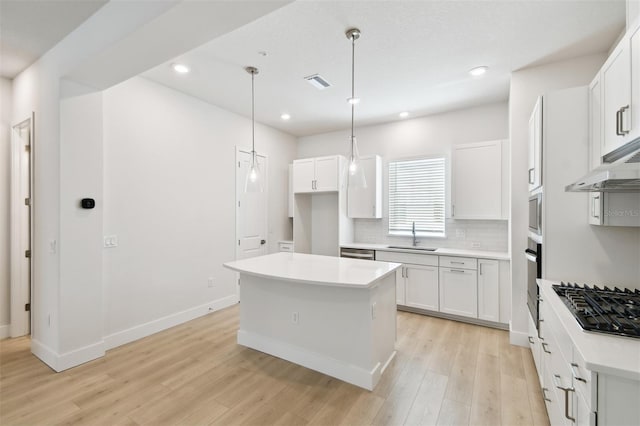 2123 1st Ave N, Saint Petersburg, FL 33713 - kitchen with appliances with stainless steel finishes, light wood-style flooring, a center island, decorative backsplash, and a sink