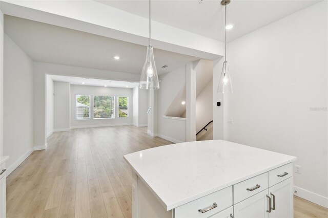 2123 1st Ave N, Saint Petersburg, FL 33713 - kitchen with open floor plan, light countertops, light wood-style flooring, white cabinets, and pendant lighting