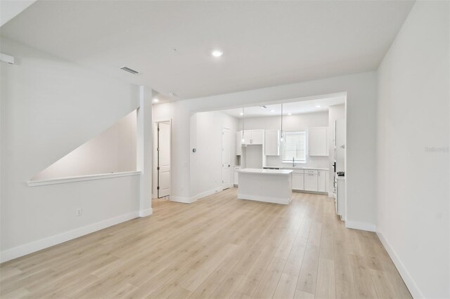 2123 1st Ave N, Saint Petersburg, FL 33713 - unfurnished living room featuring light wood-style floors, baseboards, a sink, and recessed lighting