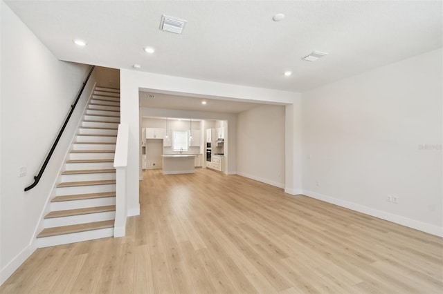 2123 1st Ave N, Saint Petersburg, FL 33713 - unfurnished living room with light wood-type flooring, stairway, baseboards, and recessed lighting
