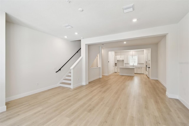 2123 1st Ave N, Saint Petersburg, FL 33713 - unfurnished living room with light wood-style flooring, stairway, baseboards, and recessed lighting