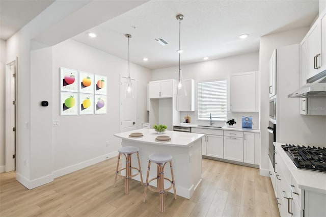 2123 1st Ave N, Saint Petersburg, FL 33713 - kitchen featuring stainless steel appliances, light wood finished floors, a kitchen island, a sink, and recessed lighting