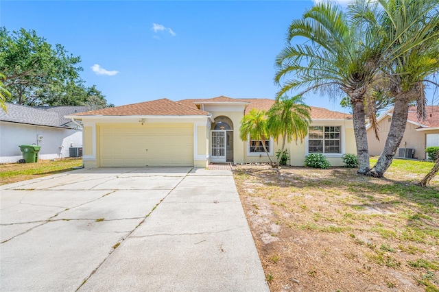 709 47th St E, Bradenton, FL 34208 - view of front facade with concrete driveway, central AC unit, stucco siding, and an attached garage
