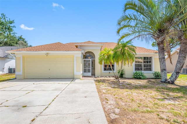709 47th St E, Bradenton, FL 34208 - view of front of house with central AC, a garage, driveway, and stucco siding