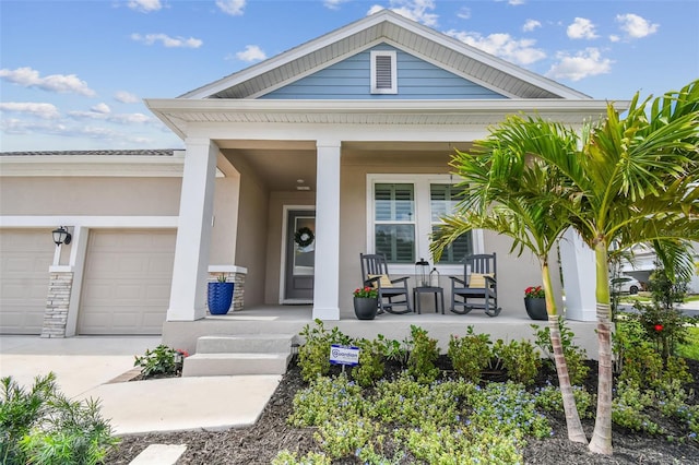 property entrance with a garage, covered porch, stucco siding, and driveway