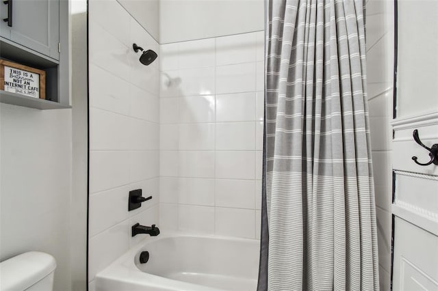 bathroom featuring shower / bathtub combination with curtain and toilet