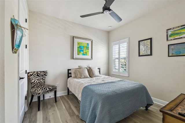 bedroom featuring a ceiling fan, baseboards, and wood finished floors