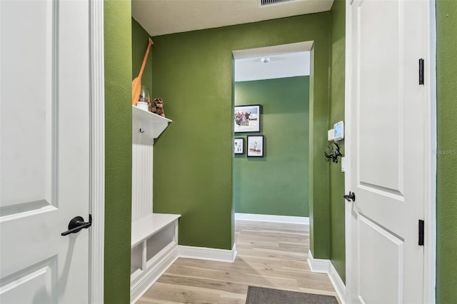 mudroom featuring baseboards, visible vents, and light wood-style floors