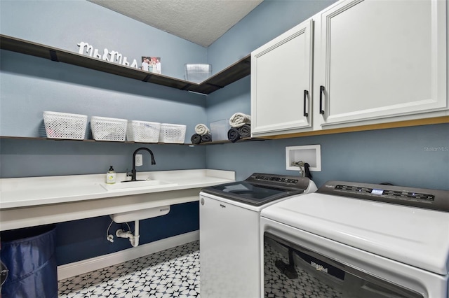 clothes washing area featuring cabinet space, a sink, baseboards, light floors, and washer and clothes dryer