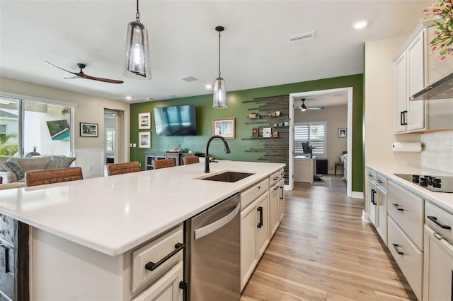 kitchen with visible vents, open floor plan, ceiling fan, a sink, and dishwasher