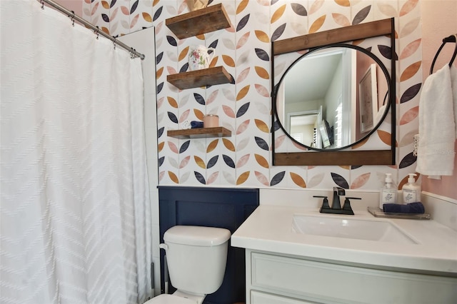 full bath featuring vanity, toilet, and wallpapered walls