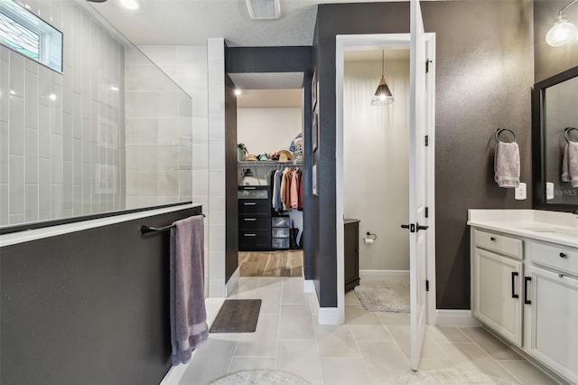 bathroom featuring a walk in shower, tile patterned flooring, vanity, and visible vents