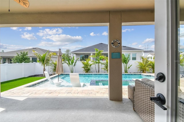 view of pool with a pool with connected hot tub, a fenced backyard, and a patio area