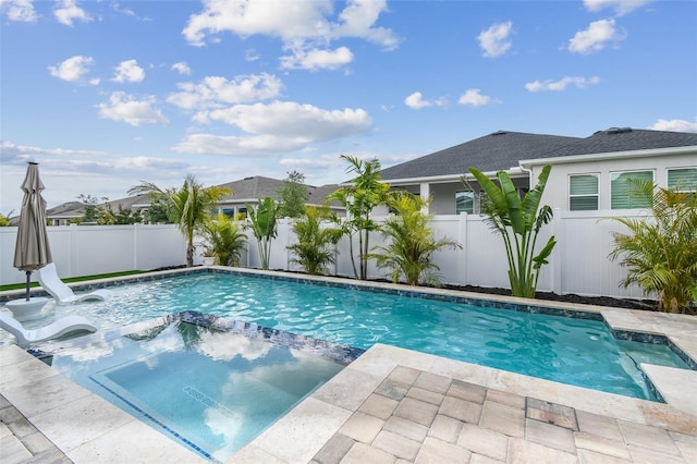 view of pool with a fenced backyard and a pool with connected hot tub