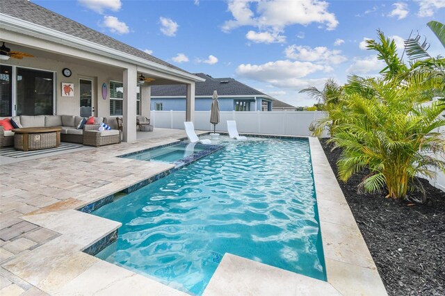 view of swimming pool with ceiling fan, an outdoor living space, a fenced backyard, and an in ground hot tub