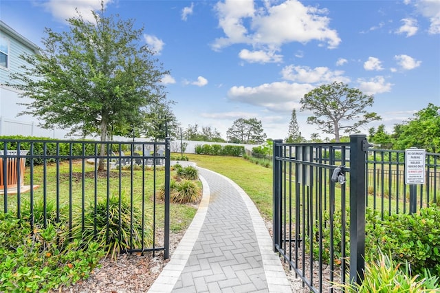 view of property's community with fence and a lawn
