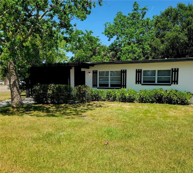 ranch-style home with stucco siding and a front yard