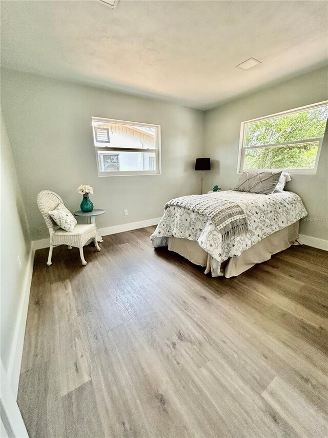 bedroom with baseboards and wood finished floors