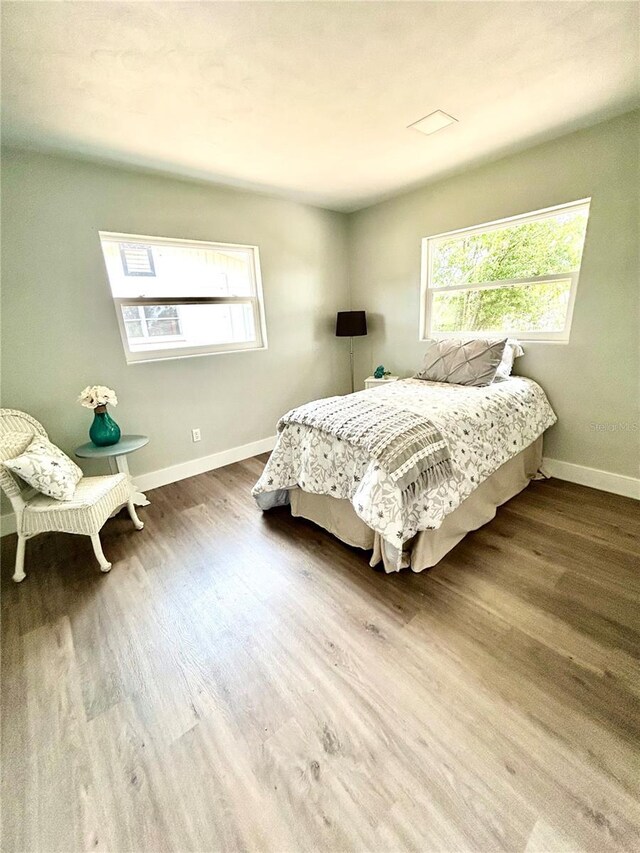 bedroom with baseboards and wood finished floors