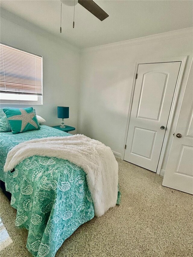 bedroom with crown molding, ceiling fan, and light carpet
