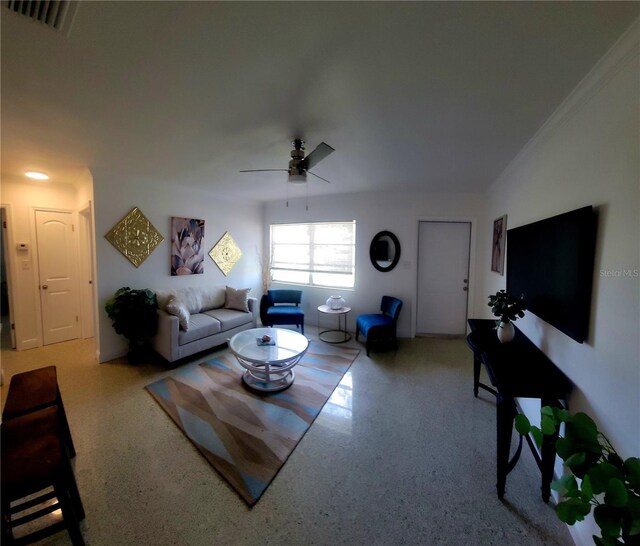 living room featuring visible vents, a ceiling fan, and ornamental molding