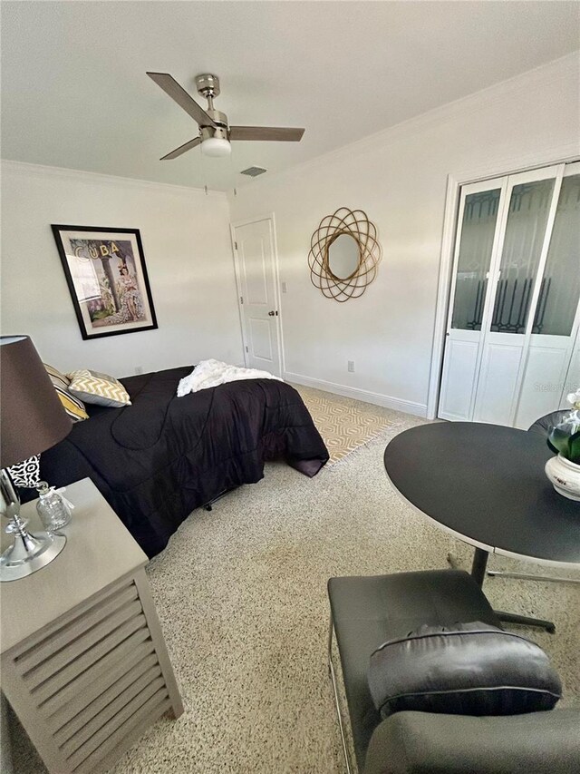 carpeted bedroom featuring ceiling fan, visible vents, ornamental molding, and baseboards