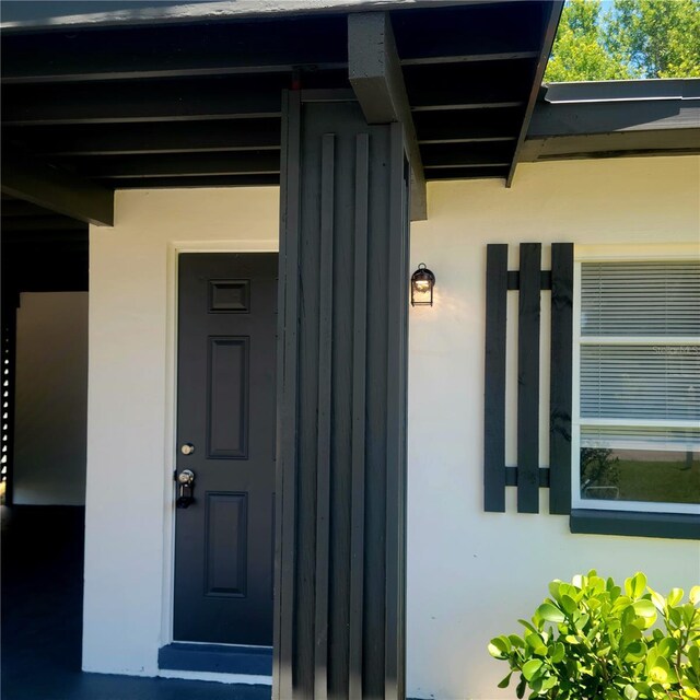 doorway to property featuring stucco siding