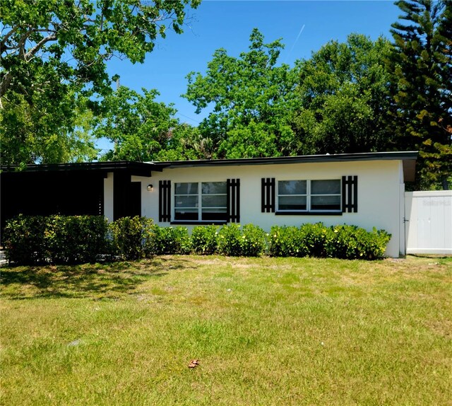 single story home featuring stucco siding and a front lawn
