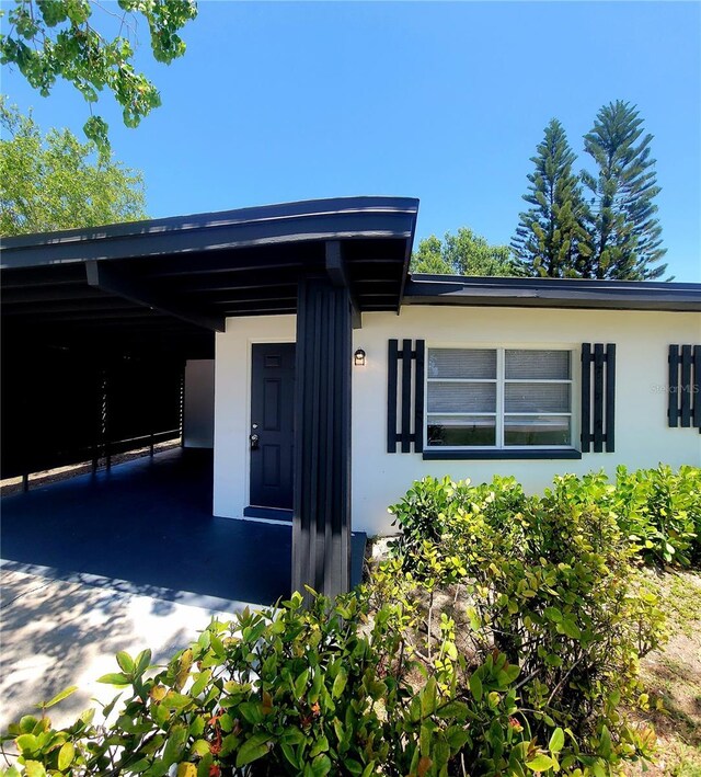 exterior space with a carport and stucco siding