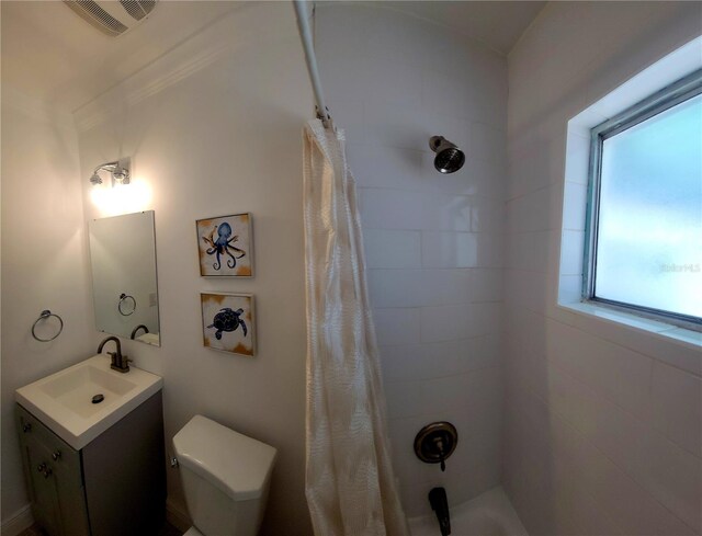 bathroom with visible vents, a tile shower, toilet, and vanity