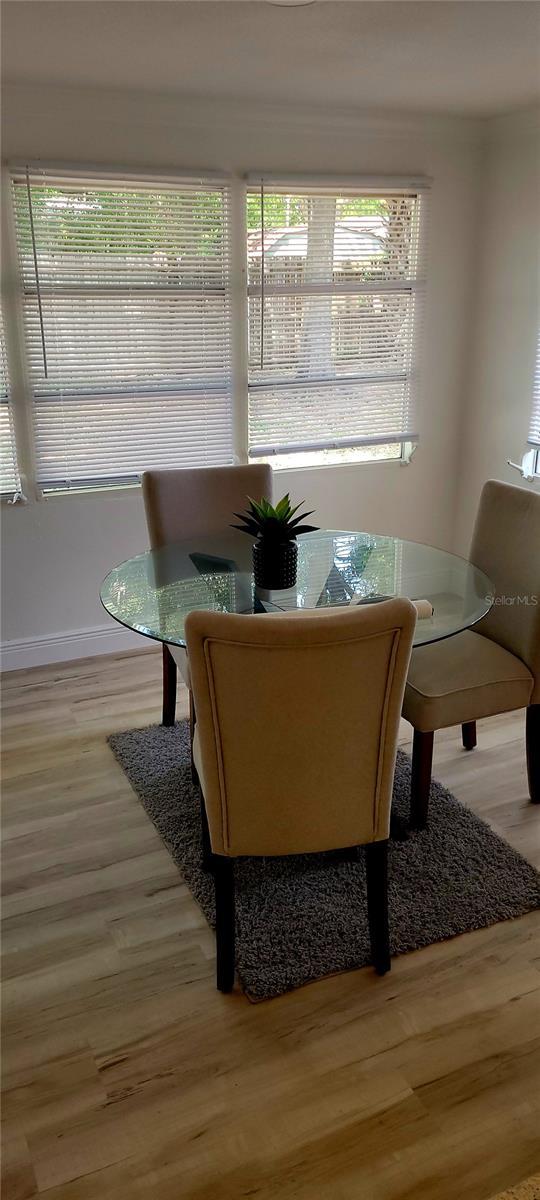 dining room featuring baseboards, a wealth of natural light, and wood finished floors