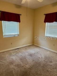 carpeted empty room with baseboards and ceiling fan
